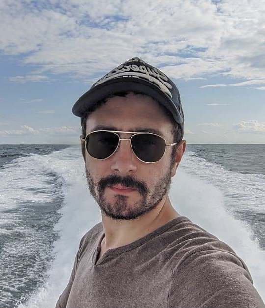 A photo of Mr. Martinez wearing sunglasses with the ocean in the background